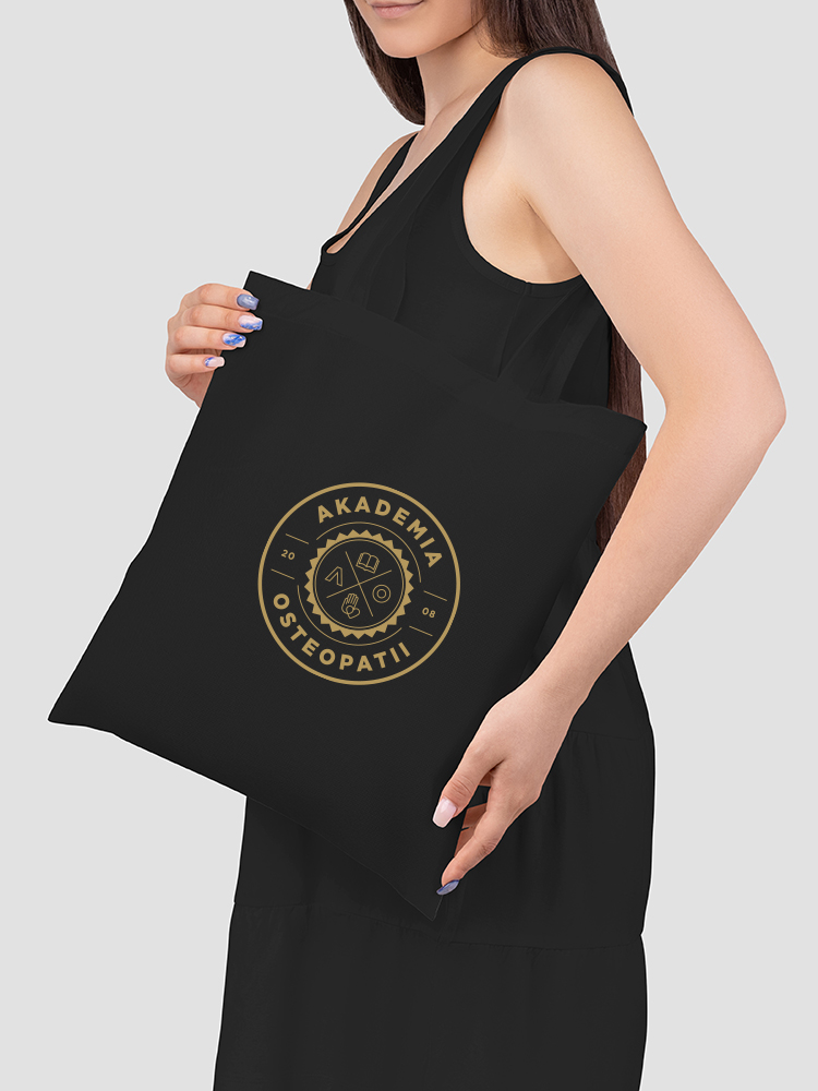 Mockup of a black totebag on the shoulder of a girl in a sundres