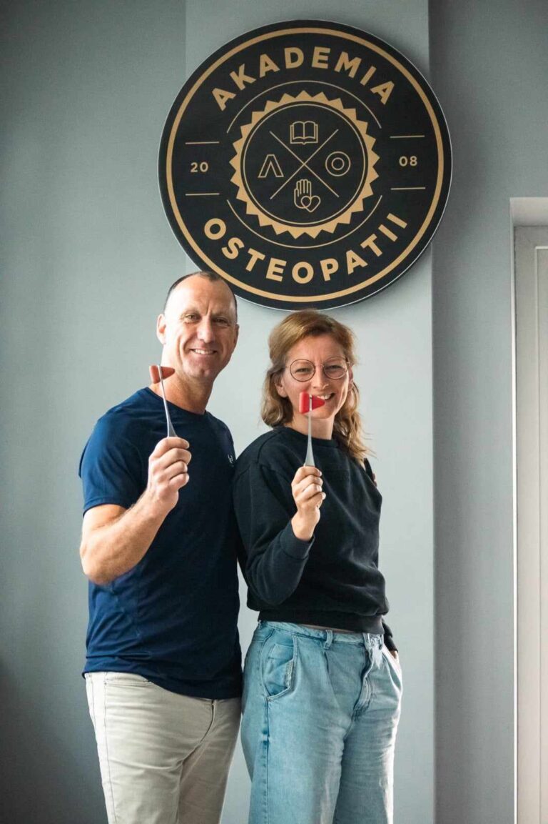 Dwoje uśmiechniętych ludzi pod logiem Akademii Osteopatii