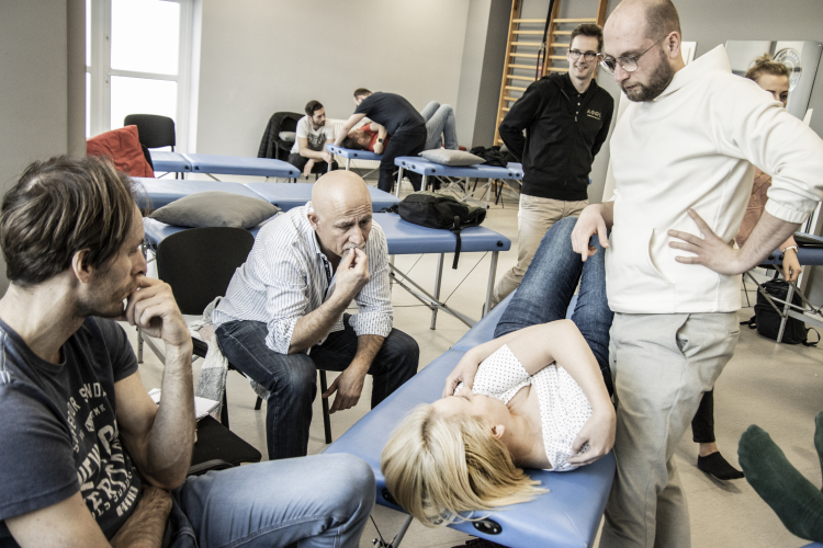 Zdjęcie przedstawia grupę ludzi podczas zajęć w Akademii Osteopatii