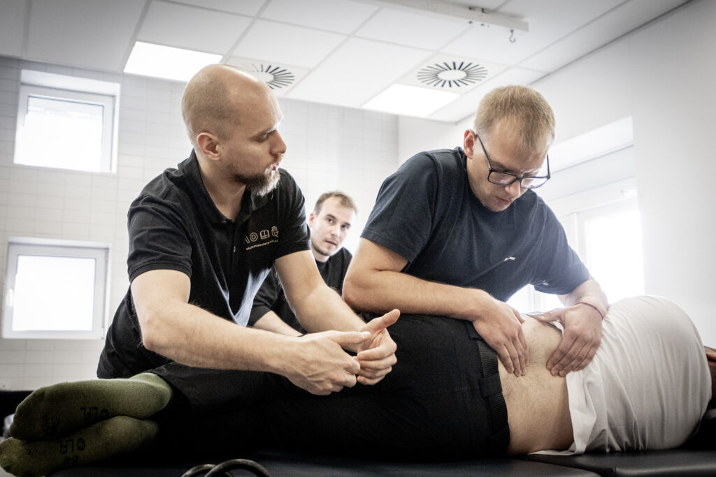 Wykładowca i uczeń podczas praktycznych zajęć w Akademii Osteopatii